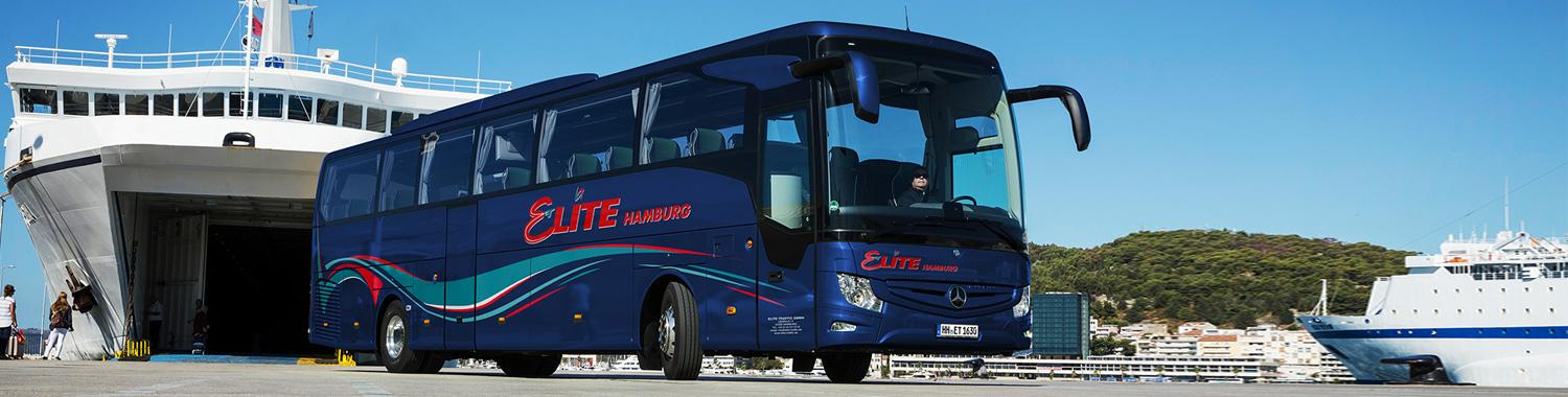 Ein Elite Reisebus steht am Hafen vor einer Fähre